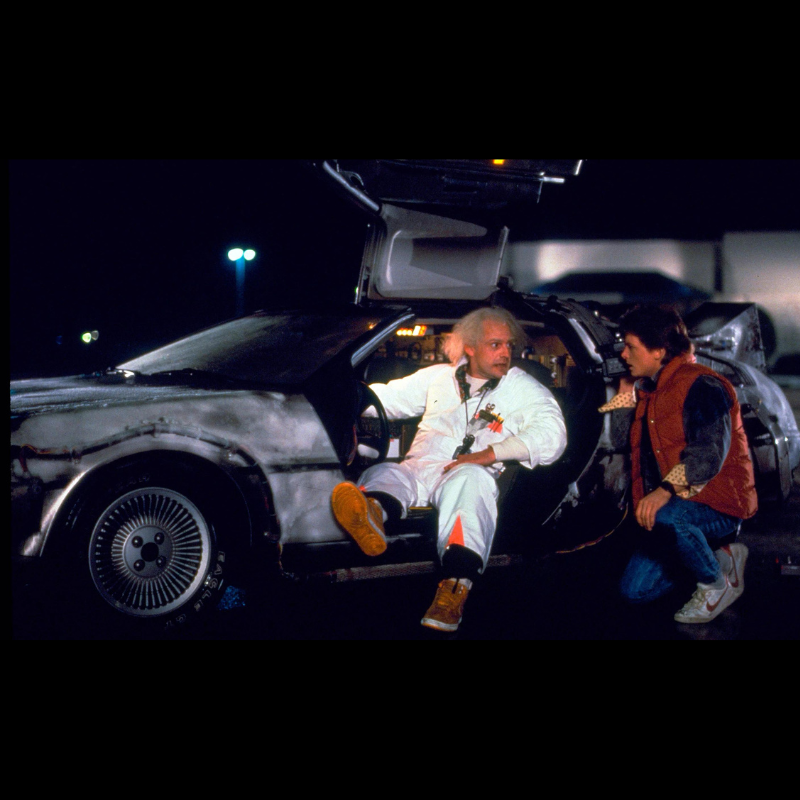 Photo du film Retour Vers le Futur on y voit les héros du film dans la voiture Delorean portant une plque comme celle proposée sur cette page.CineProps Replica Reproduction objets de film.